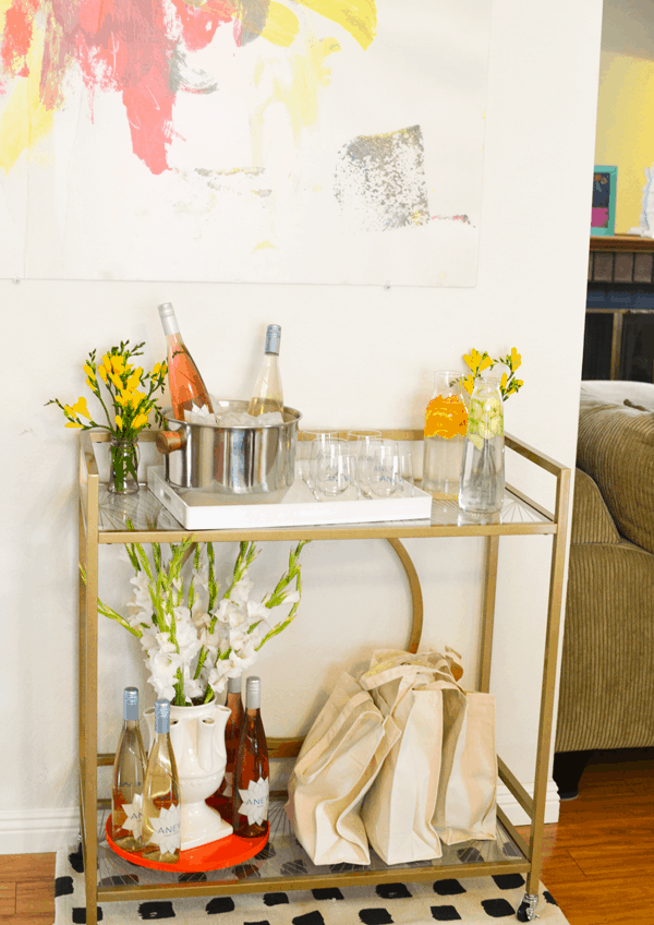 A bar cart with wine and flowers for a girl's night in.