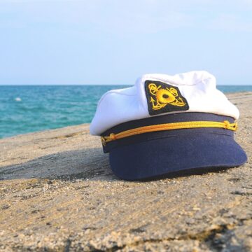 Close up of a Captain's hat on the sand at the beach.