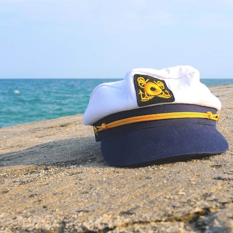 Close up of a Captain's hat on the sand at the beach.