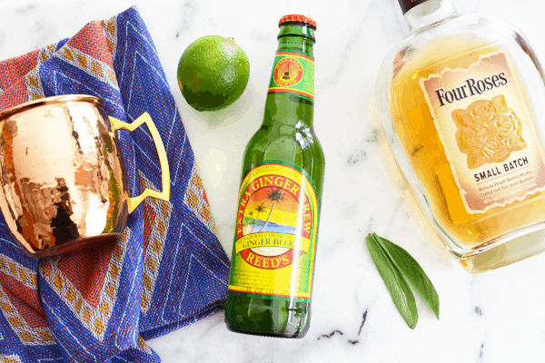 Ingredients to make a Kentucky Mule recipe laying on a marble cutting board.