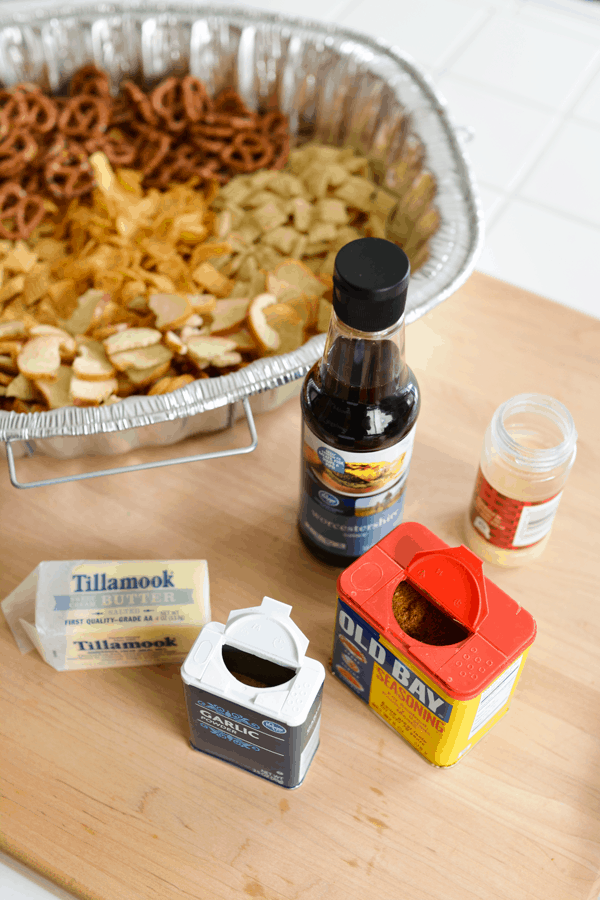 Ingredients to make a homemade Chex Mix with a disposable pan in the background. 