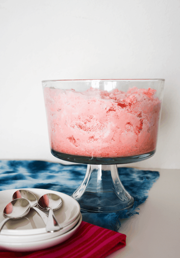 Strawberry jello angel food cake in a trifle bowl on a table. 