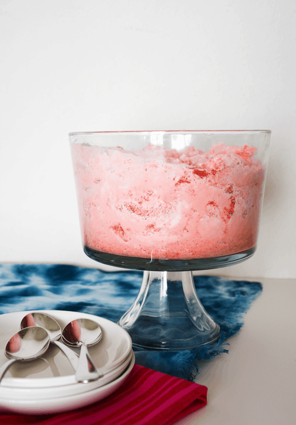 Bolo de gelatina de morango com anjo em uma tigela sobre uma mesa.