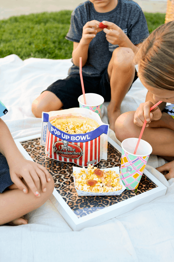 Kids enjoying popcorn and their snacks for a movie party. 