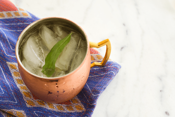 Bourbon Moscow Mule in a copper mug on a marble table.