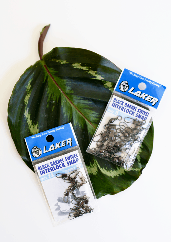 A faux leaf on the table with two packages of snap swivels to make a diy bracelet.