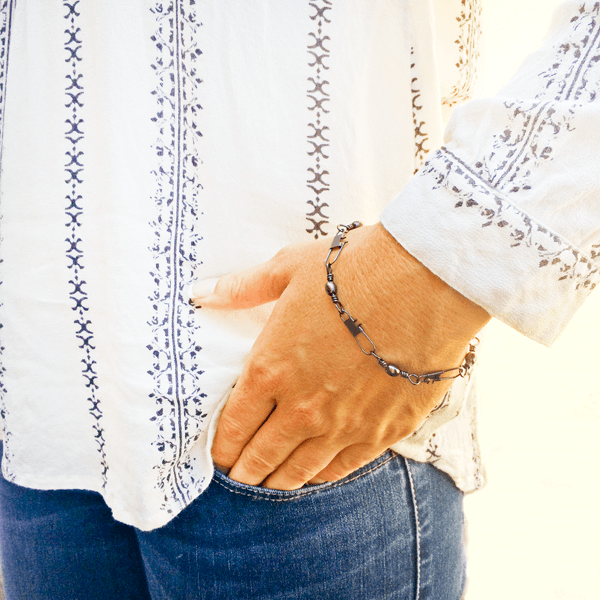 Woman wearing a homemade bracelet made from snap swivel fishing tackle.