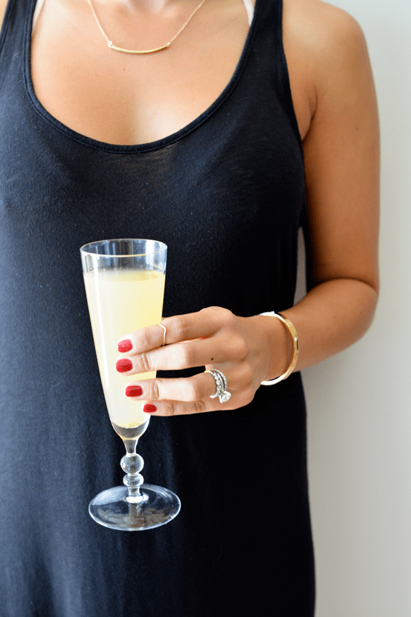 Girl holding a spiced pear bellini at a party.