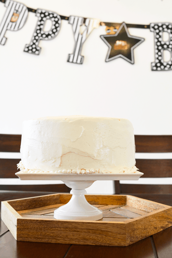 A white frosted 2-layer cake on a cake pedestal.