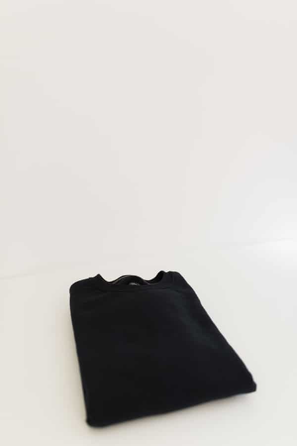 A plain black sweatshirt that is about to be reverse dyed using bleach. 