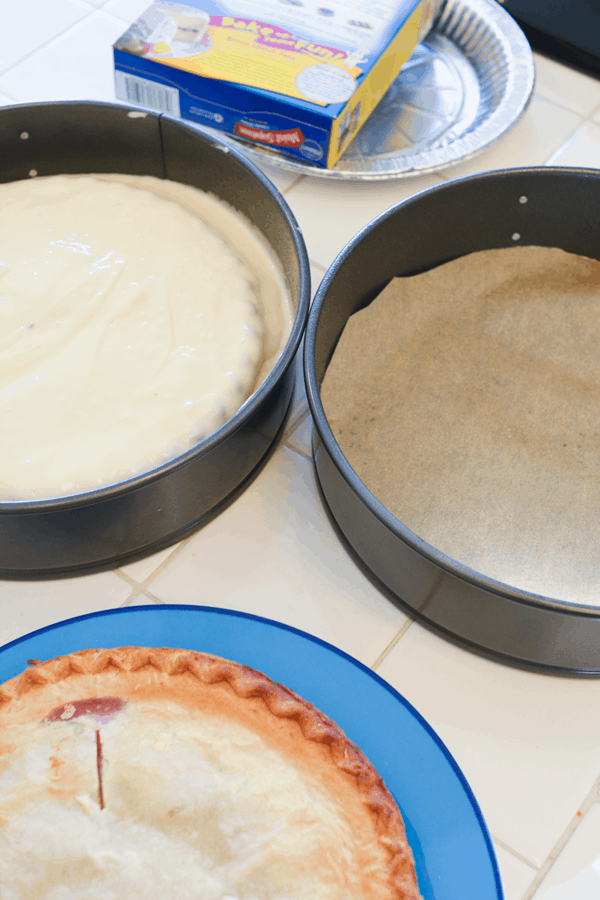 2 springform pans on a counter with pie and cake batter in one. 