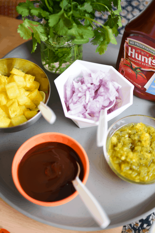 Set out a hot dog toppings bar at your next bbq party! Be sure to set out the classics like ketchup, mustard and pickle relish. But also set out some new flavors. Here I set out BBQ sauce, pineapple and cilantro. 