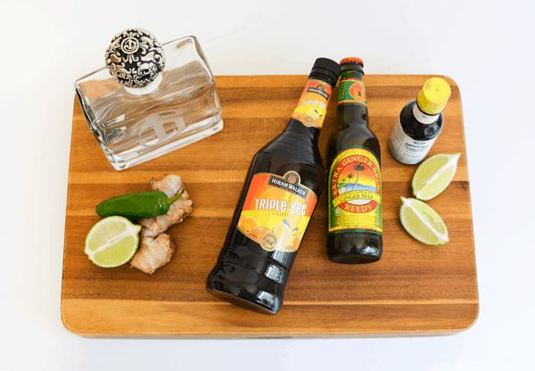 Ingredients to make a spicy Mexican Mule on a wooden cutting board.