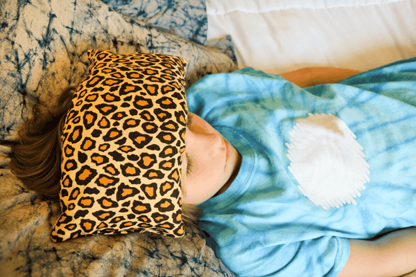 Child using a headache relief bag while laying down.