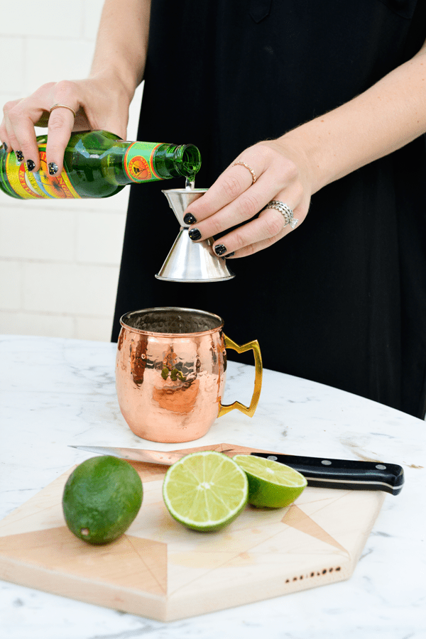 Pouring ginger beer for a absolut vodka mule recipe.
