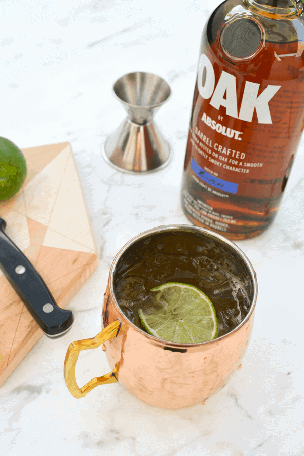 Oak by Absolut vodka mule in a copper mule mug on a table.