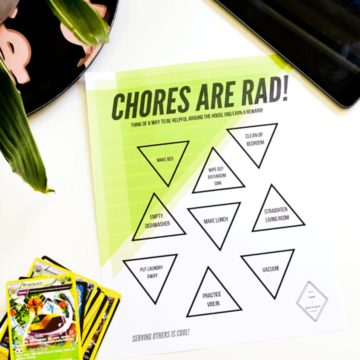 A printable chore list on a table next to Pokemon cards, a tray with a plant and an ipad.