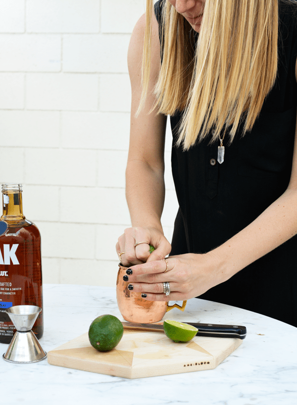 Squeezing fresh lime juice for a oak by absolut cocktail.