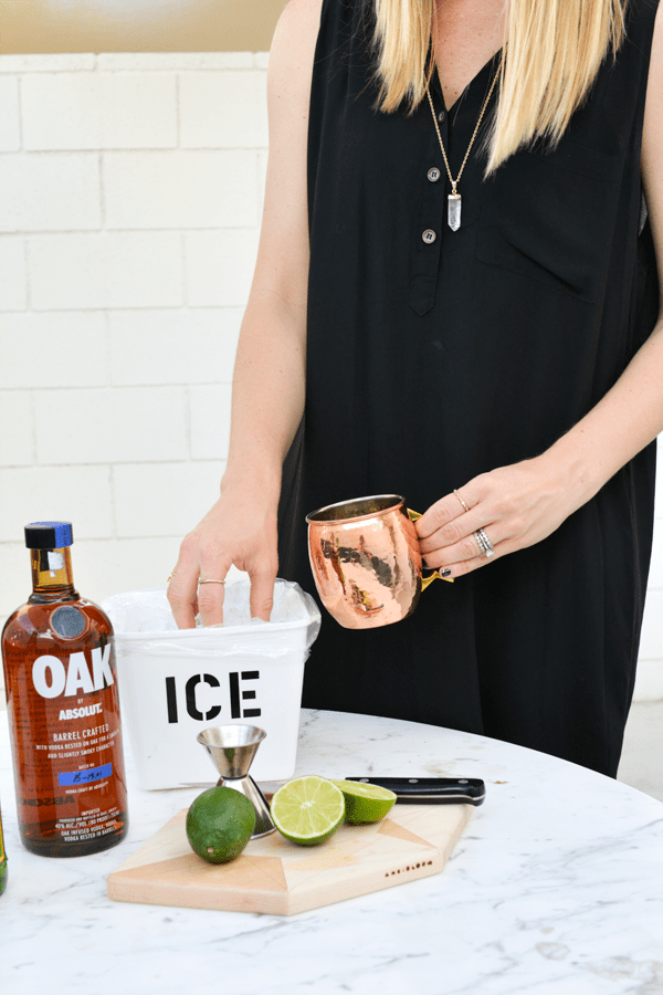 A woman making vodka mule with Oak by Absolut.