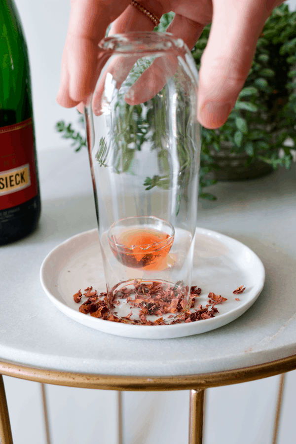 Dipping the edge of a glass in dried rose petals. 
