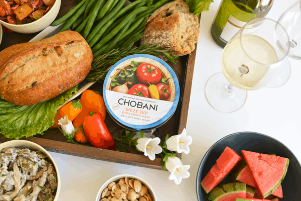 Close up of a container of Chobani dip on a veggie platter. 