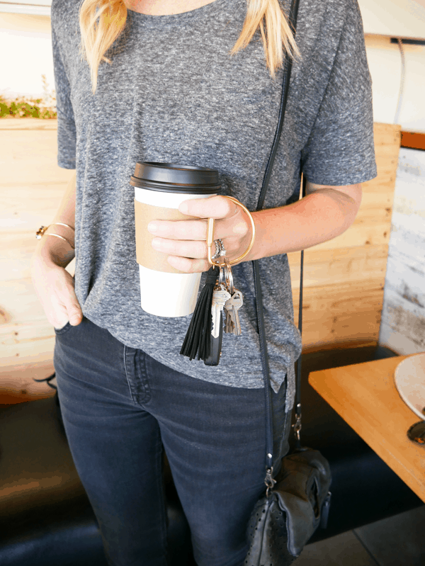 Woman in black jeans, a grey tshirt and my DIY keychain to use with essential oils. 