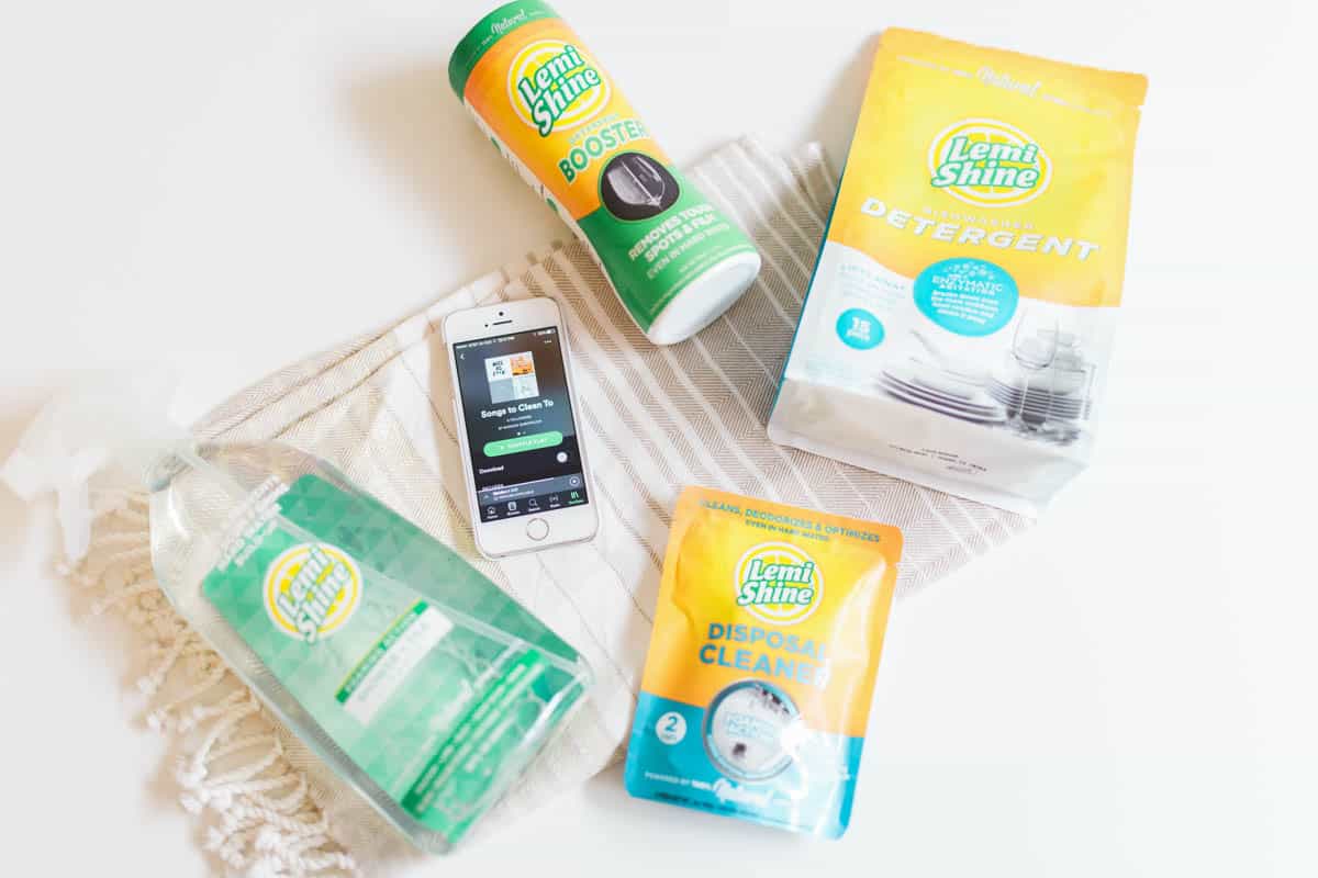 An overhead view of Lemi Shine cleaning products and an iphone showing a music playlist.
