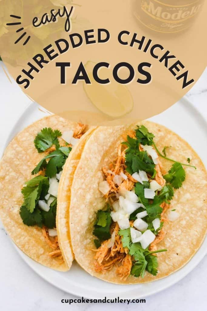 Text - Easy Shredded Chicken Tacos over a white plate holding two chicken tacos.