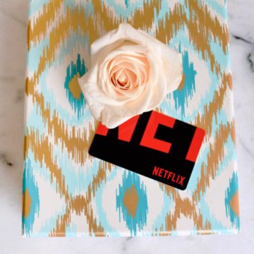 A wrapped gift box with a Netflix gift card on top.