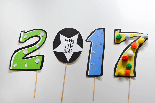 Printed out paper photo booth props that say "2017" with sticks attached.