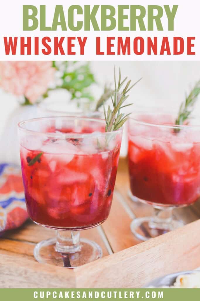 servings of blackberry whiskey lemonade in glasses on a tray with rosemary garnish
