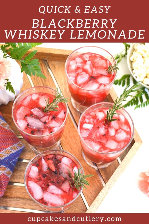 4 servings of Blackberry Whiskey Lemonade on a tray on a party table.