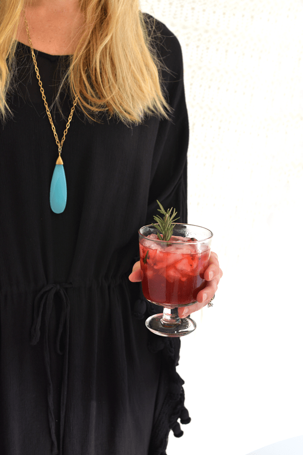 girl holding a Blackberry Whiskey Lemonade cocktail.