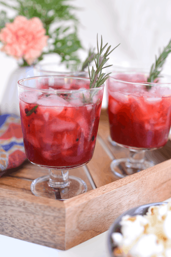 Several glasses of a fresh Blackberry Whiskey Lemonade cocktail on a girl's night in party table