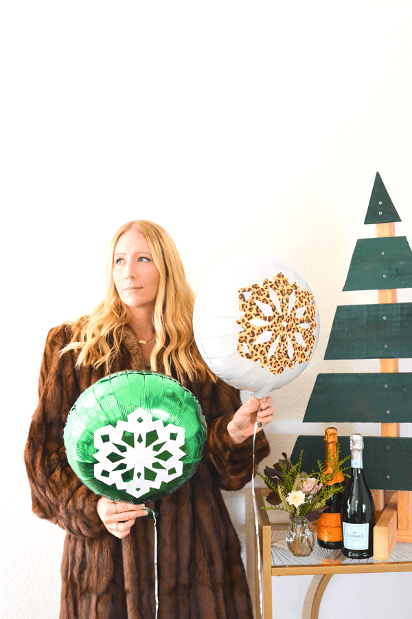 Woman holding diy snowflake balloons for Christmas. 