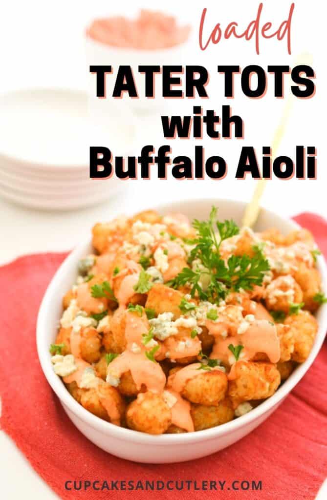 A white bowl holding loaded tater tots with a buffalo aioli and blue cheese crumbles.