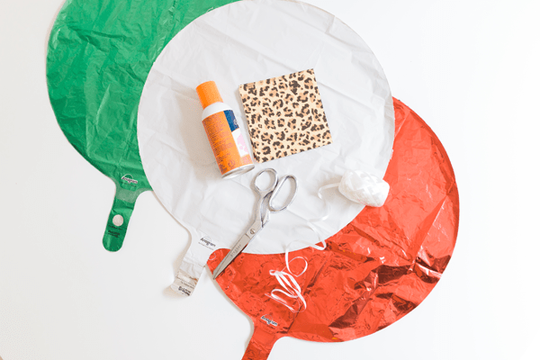 Mylar balloons and napkins on a table to make a diy holiday decoration. 