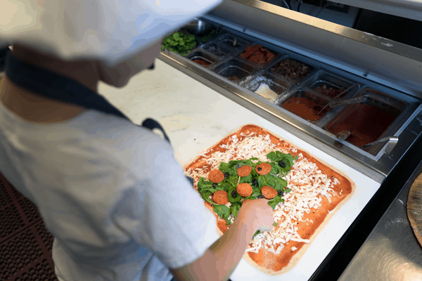 Making a Christmas tree pizza with basil leaves and pepperoni! 