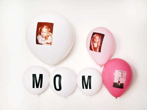 White and pink balloons with photos on them and some that spell out "mom".