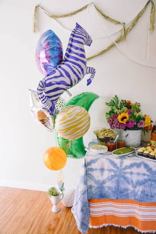 Balloon bouquet next to a party table.