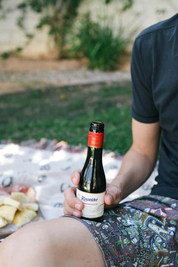 Man holding a small bottle of Riunite Lambrusco wine.