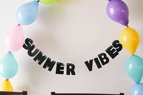 Summer vibes garland between a DIY balloon decoration.