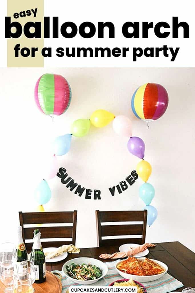 Text: Easy balloon arch for a summer party, on top of an image of a balloon arch and garland behind a table topped with food and beverages.
