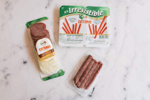 Salami and cheese and mini salami stick snack packs on a table. 