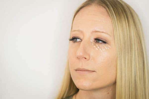 Applying a few dots of concealer to the undereye area.