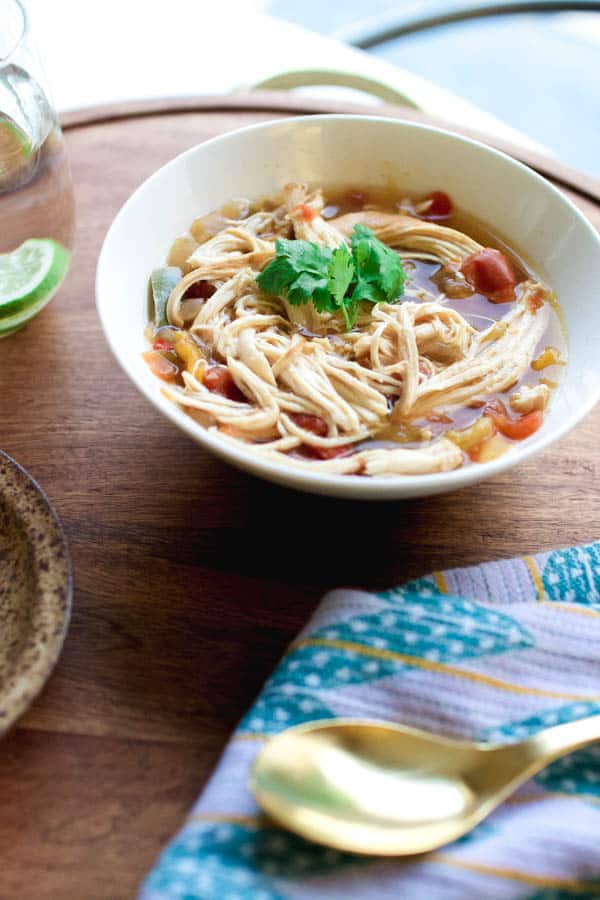 A bowl on a tray holding a portion of a Chicken Fajita Soup topped with cilantro. 