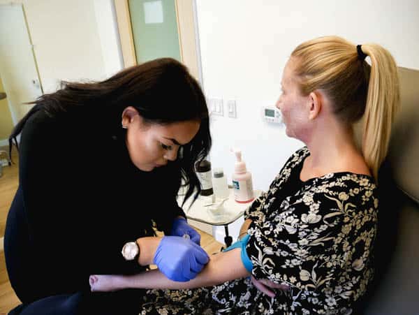 Woman getting her blood drawn for her microneedling treatment with prp facial.