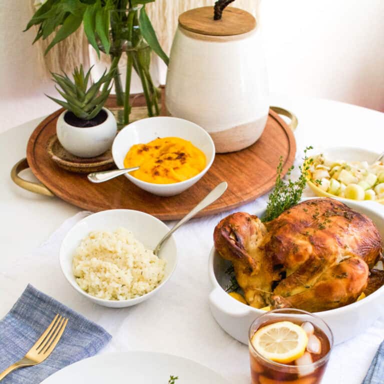 A dinner table with rotisserie chicken and healthy side dishes.