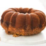 Bundt cake on a round marble platter on a table.