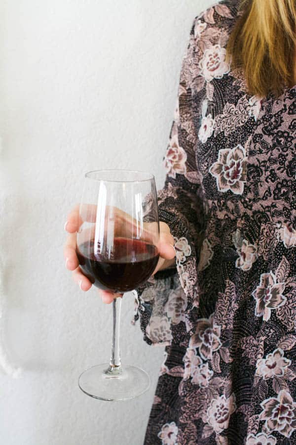 Woman holding a glass of red wine. 